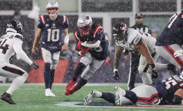 New England Patriots running back Rhamondre Stevenson, middle, runs against the Houston Texans during the second half of an NFL divisional playoff football game, Sunday, Jan. 18, 2026, in Foxborough, Mass. (AP Photo/Mark Stockwell)