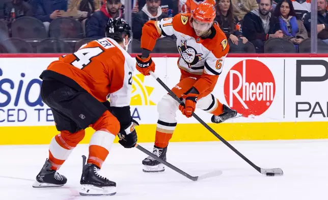 Anaheim Ducks' Cutter Gauthier, right, shoots the puck against Philadelphia Flyers' Nick Seeler, left, during the first period of an NHL hockey game, Tuesday, Jan. 6, 2026, in Philadelphia. (AP Photo/Chris Szagola)
