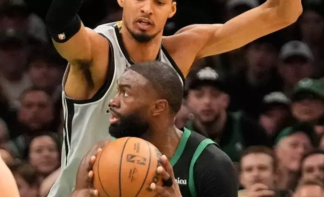 San Antonio Spurs forward Victor Wembanyama defends against Boston Celtics guard Jaylen Brown (7) during the second half of an NBA basketball game, Saturday, Jan. 10, 2026, in Boston. (AP Photo/Robert F. Bukaty)