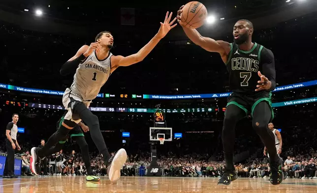 Boston Celtics guard Jaylen Brown (7) grabs a defensive rebound against San Antonio Spurs forward Victor Wembanyama (1) during the second half of an NBA basketball game, Saturday, Jan. 10, 2026, in Boston. (AP Photo/Robert F. Bukaty)