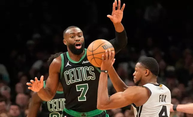 Boston Celtics guard Jaylen Brown (7) guards San Antonio Spurs guard De'aaron Fox (4) during the first half of an NBA basketball game, Saturday, Jan. 10, 2026, in Boston. (AP Photo/Robert F. Bukaty)