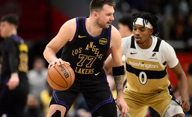 Los Angeles Lakers guard Luka Doncic (77) dribbles against Washington Wizards guard Bilal Coulibaly (0) during the first half of an NBA basketball game, Friday, Jan. 30, 2026, in Washington. (AP Photo/Nick Wass)