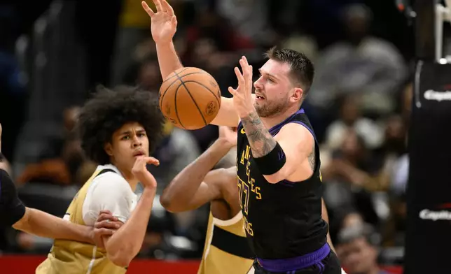 Los Angeles Lakers guard Luka Doncic, right, chases the ball during the first half of an NBA basketball game against the Washington Wizards, Friday, Jan. 30, 2026, in Washington. (AP Photo/Nick Wass)