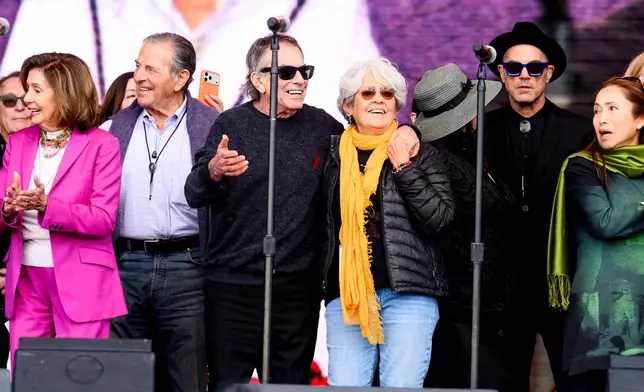 Musicians Joan Baez and Mickey Hart embrace during a memorial for Grateful Dead guitarist Bob Weir on Saturday, Jan. 17, 2026, in San Francisco. At left are Paul and Nancy Pelosi. (AP Photo/Noah Berger)