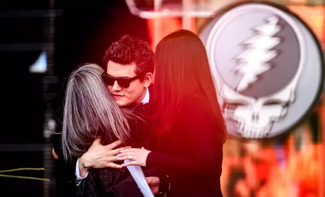 John Mayer embraces Natascha Münter during a public memorial for her husband, Grateful Dead guitarist Bob Weir, on Saturday, Jan. 17, 2026, in San Francisco. (AP Photo/Noah Berger)