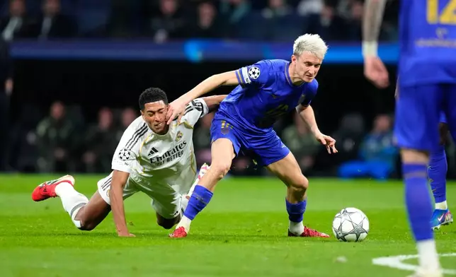 Monaco's Aleksandr Golovin fights for the ball against Real Madrid's Jude Bellingham during the Champions League opening phase soccer match between Real Madrid and Monaco in Madrid on Tuesday, Jan. 20, 2026. (AP Photo/Jose Breton)