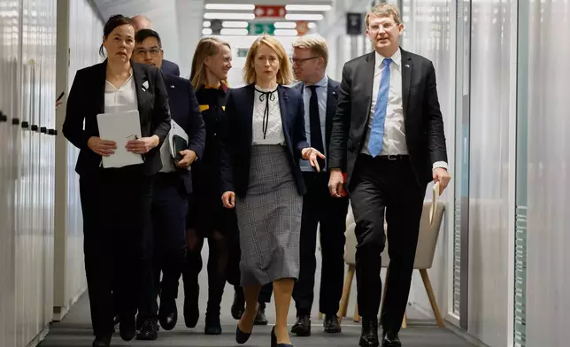 European Union foreign policy chief Kaja Kallas, center, walks with Minister for Foreign Affairs and Research of Greenland Vivian Motzfeldt, left, and Denmark's Defense Minister Troels Lund Poulsen, right, prior to a meeting at EU headquarters in Brussels, Monday, Jan. 19, 2026. (AP Photo/Geert Vanden Wijngaert)