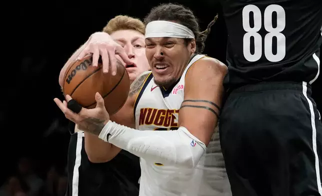 Brooklyn Nets forward Danny Wolf, left, steals the ball from Denver Nuggets forward Aaron Gordon during the second half of an NBA basketball game, Sunday, Jan. 4, 2026, in New York. (AP Photo/Yuki Iwamura)