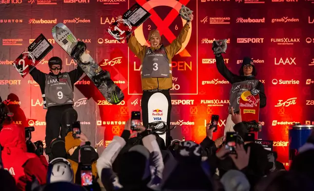 Winner Scotty James of Australia, center, second placed Campbell Melville Ives of New Zealand, left, and third placed Valentino Guseli of Australia after the final run of the Snowboard Halfpipe World Cup at Laax Open, in Laax, Switzerland, Saturday, Jan. 17, 2026. (Andreas Becker/Keystone via AP)