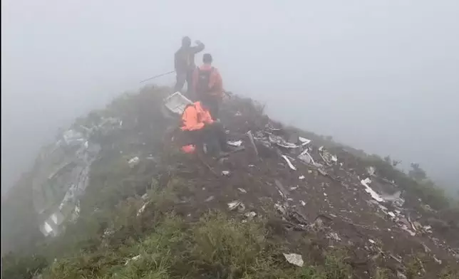 In this photo provided by the Indonesian National Search and Rescue Agency (BASARNAS), members of its rescue team conduct a searching operation amid debris of an airplane around Mount Bulusaraung, South Sulawesi province, Indonesia, Sunday, Jan. 18, 2026, after the turboprop ATR 42-500 lost contact Saturday. (BASARNAS via AP)