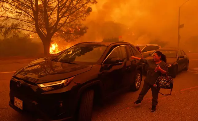 FILE - A woman cries as the Palisades Fire advances in the Pacific Palisades neighborhood of Los Angeles, Jan. 7, 2025. (AP Photo/Etienne Laurent, File)