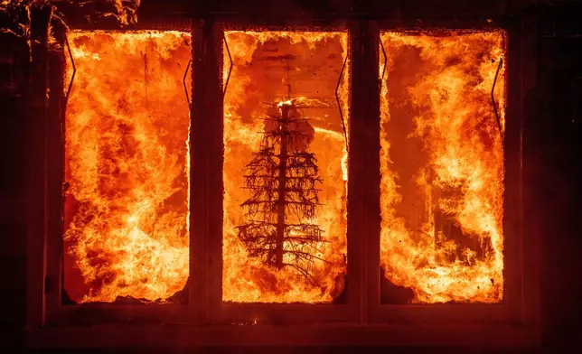 FILE - The Palisades Fire burns a Christmas tree inside a residence in the Pacific Palisades neighborhood of Los Angeles, Jan. 7, 2025. (AP Photo/Ethan Swope, File)
