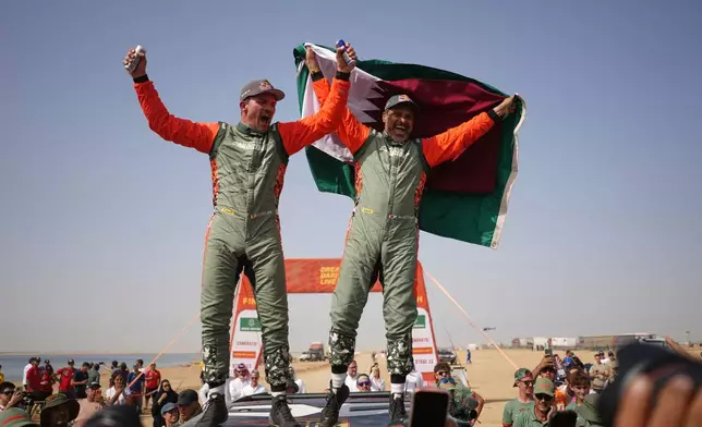 Driver Nasser Al-Attiyah of Qatar, right, and co-driver Fabian Lurquin of Belgium celebrate winning the Dakar Rally after the thirteenth stage with a start and finish in Yanbu, Saudi Arabia, Saturday, Jan.17, 2026. (AP Photo/Thibault Camus)