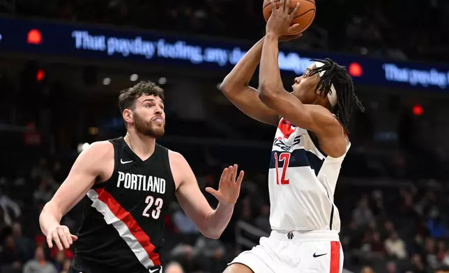 Washington Wizards guard Tre Johnson (12) goes to shoot over Portland Trail Blazers center Donovan Clingan (23) during the first half of an NBA basketball game, Tuesday, Jan. 27, 2026, in Washington. (AP Photo/John McDonnell)