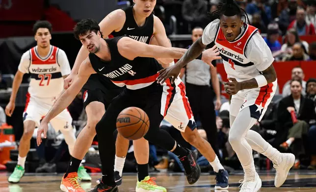 Washington Wizards guard Jamir Watkins, right, knocks the ball loose from Portland Trail Blazers forward Deni Avdija for steal during the first half of an NBA basketball game, Tuesday, Jan. 27, 2026, in Washington. (AP Photo/John McDonnell)