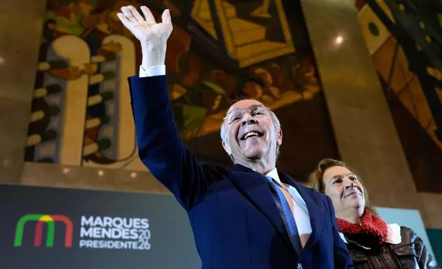 Presidential candidate Luis Marques Mendes, from the center-right Social Democratic Party, with his wife Rosa Sofia Salazar, gestures to supporters while campaigning for Sunday's presidential election, in Lisbon, Portugal, Friday, Jan. 16, 2026. (AP Photo/Armando Franca)