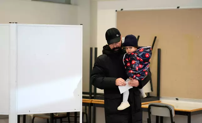 A man folds his ballot as he votes in Portugal's presidential election at a polling station in Lisbon, Sunday, Jan. 18, 2026. (AP Photo/Armando Franca)