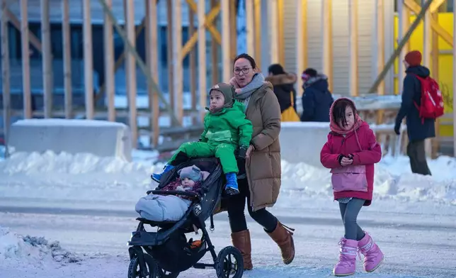 FILE - A woman pushes a stroller with her children in Nuuk, Greenland, Thursday, Jan. 15, 2026. (AP Photo/Evgeniy Maloletka, File)