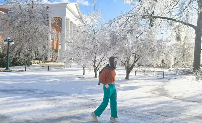 A woman walks across the campus of the University of Mississippi in Oxford, Miss. on Monday, Jan. 26, 2026, following a weekend ice storm. (AP Photo/Bruce Newman)