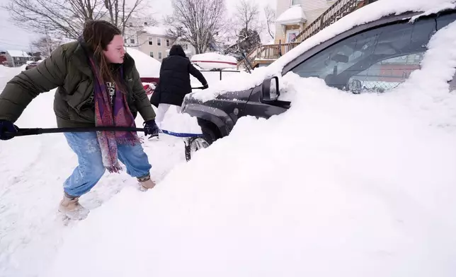Emma Teske shovels out her car following a winter storm that dumped more than a foot and a half of snow across the region, Tuesday, Jan. 27, 2026, in Haverhill, Mass. (AP Photo/Charles Krupa)