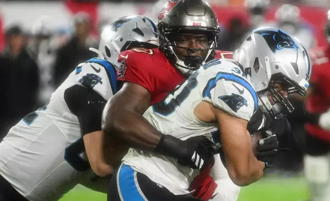 Tampa Bay Buccaneers linebacker Yaya Diaby, top, tackles Carolina Panthers running back Chuba Hubbard during the second half of an NFL football game Saturday, Jan. 3, 2026, in Tampa, Fla. (AP Photo/Jason Behnken)