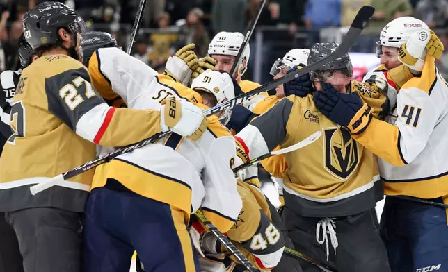 Vegas Golden Knights defenseman Jeremy Lauzon (5) and Nashville Predators defenseman Nicolas Hague (41) fight during the second period of an NHL hockey game Saturday, Jan. 17, 2026, in Las Vegas. (AP Photo/Ian Maule)