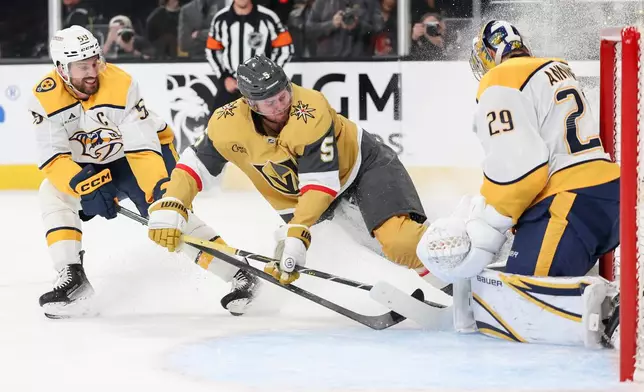 Vegas Golden Knights defenseman Jeremy Lauzon (5) collides into Nashville Predators goaltender Justus Annunen (29) while skating against Predators defenseman Roman Josi (59) during the second period of an NHL hockey game Saturday, Jan. 17, 2026, in Las Vegas. (AP Photo/Ian Maule)