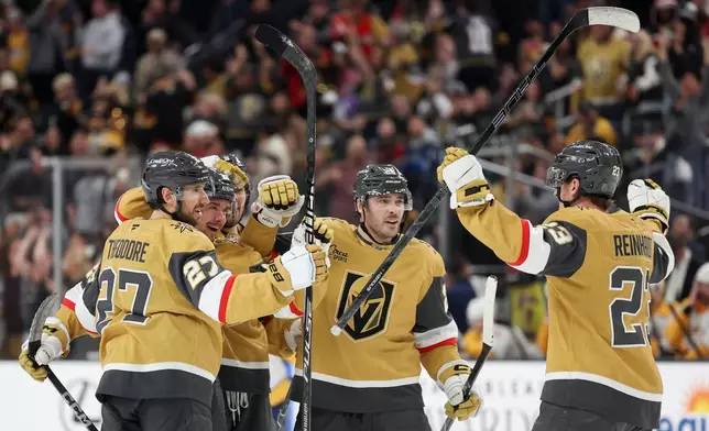 Vegas Golden Knights defenseman Shea Theodore (27), right wing Alexander Holtz (26), center Tanner Laczynski (28) and left wing Cole Reinhardt (23) celebrate after Holtz's goal against the Nashville Predators during the second period of an NHL hockey game Saturday, Jan. 17, 2026, in Las Vegas. (AP Photo/Ian Maule)