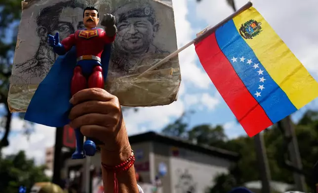 A government supporter holds an action figure of Super Bigote during a protest demanding the release of President Nicolas Maduro, who was captired by U.S. forces, in Caracas, Venezuela, Sunday, Jan. 4, 2026. (AP Photo/Ariana Cubillos)