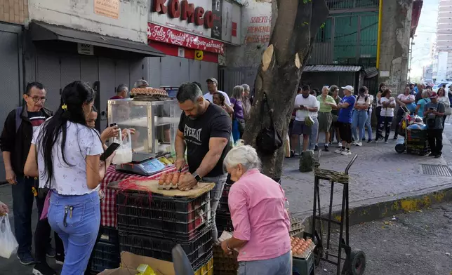 Shoppers line up to buy eggs in Caracas, Venezuela, Sunday, Jan. 4, 2026. (AP Photo/Ariana Cubillos)