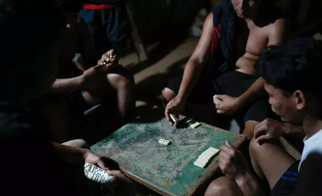 Miners play dominos after working in the gold mining town of El Callao, Venezuela, Thursday, Jan. 22, 2026. (AP Photo/Matias Delacroix)
