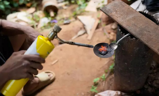 A miner burns a gold-mercury amalgam to evaporate mercury and isolate gold at a gold mining site El Callao, Venezuela, Tuesday, Jan. 22, 2026. (AP Photo/Matias Delacroix)