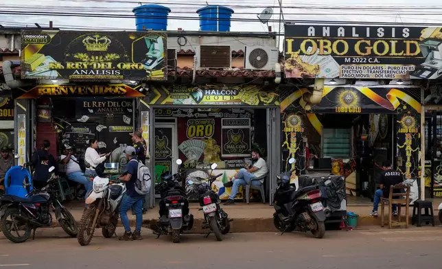 Vendors weigh and trade gold at gold-buying shops in El Callao, Venezuela, Thursday, Jan. 22, 2026. (AP Photo/Matias Delacroix)