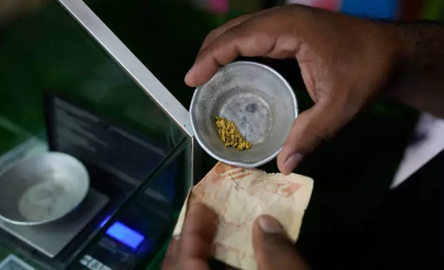 A vendor buys gold at a gold buying shop in El Callao, Venezuela, Tuesday, Jan. 22, 2026. (AP Photo/Matias Delacroix)