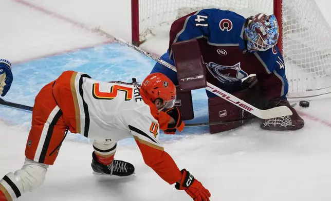 Colorado Avalanche goaltender Scott Wedgewood, back, stops a shot from Anaheim Ducks right wing Beckett Sennecke in the first period of an NHL hockey game, Wednesday, Jan. 21, 2026, in Denver. (AP Photo/David Zalubowski)