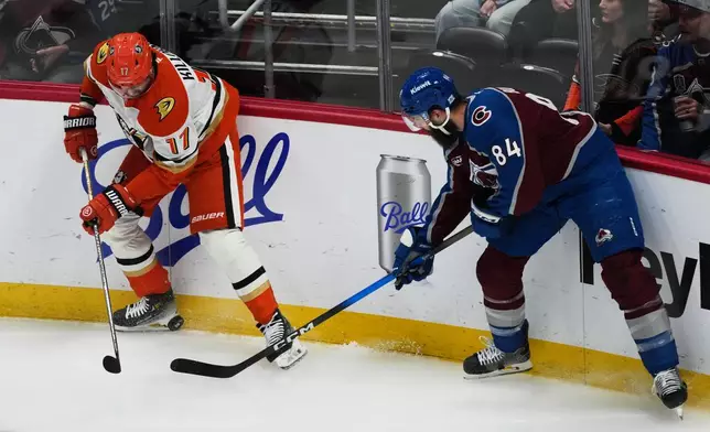 Anaheim Ducks left wing Alex Killorn, left, battles for control of the puck with Colorado Avalanche defenseman Brent Burns in the first period of an NHL hockey game Wednesday, Jan. 21, 2026, in Denver. (AP Photo/David Zalubowski)