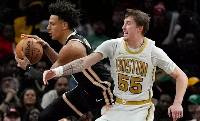Atlanta Hawks forward Jalen Johnson (1) takes a rebound against Boston Celtics guard Baylor Scheierman (55) during the first half of an NBA basketball game, Saturday, Jan. 17, 2026, in Atlanta. (AP Photo/Mike Stewart)