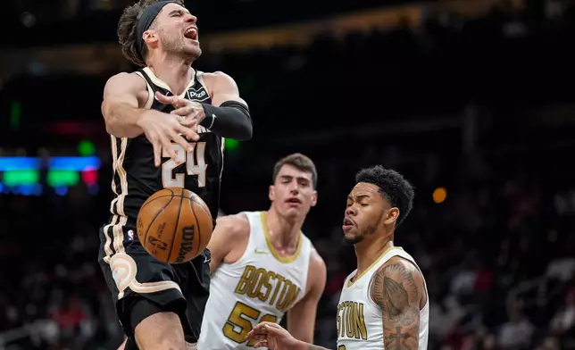 Atlanta Hawks forward Corey Kispert (24) shoots against Boston Celtics guard Anfernee Simons (4) during the first half of an NBA basketball game, Saturday, Jan. 17, 2026, in Atlanta. (AP Photo/Mike Stewart)