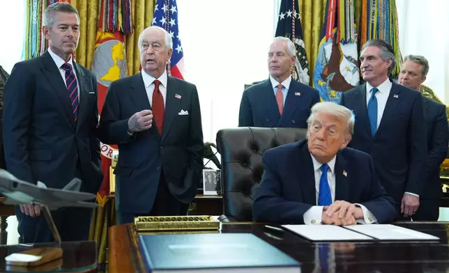 Roger Penske, second left, speaks before President Donald Trump signs executive orders in the Oval Office of the White House, Friday, Jan. 30, 2026, in Washington. (AP Photo/Evan Vucci)
