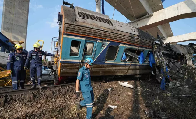 Rescuers work amidst the wreckage after a construction crane fell into a passenger train in Nakhon Ratchasima province, Thailand, Wednesday, Jan.14, 2026. (AP Photo/Sakchai Lalit))