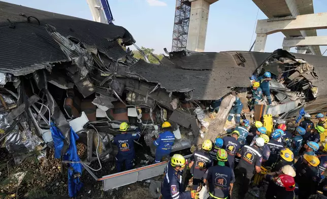 Rescuers work amidst the wreckage after a construction crane fell into a passenger train in Nakhon Ratchasima province, Thailand, Wednesday, Jan.14, 2026. (AP Photo/Sakchai Lalit))