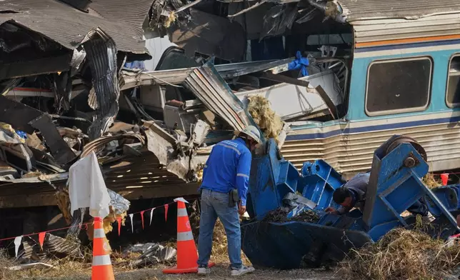 Train workers check the wreckage of train at the site where a construction crane fell into a passenger train on Wednesday, in Nakhon Ratchasima province, Thailand, Thursday, Jan. 15, 2026. (AP Photo/Sakchai Lalit)