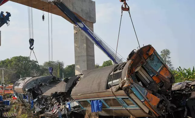 Rescuers try to lift the wreckage after a construction crane fell into a passenger train in Nakhon Ratchasima province, Thailand, Wednesday, Jan.14, 2026. (AP Photo/Sakchai Lalit))