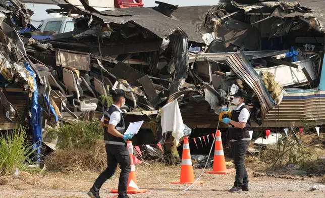 Forensic workers inspect the site of a train accident, a day after a construction crane fell into a passenger train in Nakhon Ratchasima province, Thailand, Thursday, Jan. 15, 2026. (AP Photo/Sakchai Lalit)