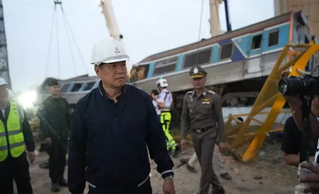 Thailand's Prime Minister Anutin Charnvirakul visits the site where a construction crane fell onto a passenger train in Nakhon Ratchasima province, Thailand, Wednesday, Jan. 14, 2026. (AP Photo/Sakchai Lalit)