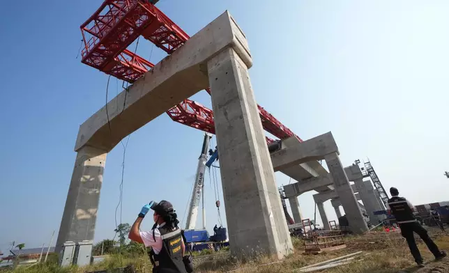Forensic workers inspect the train accident site, a day after a construction crane fell into a passenger train in Nakhon Ratchasima province, Thailand, Thursday, Jan. 15, 2026. (AP Photo/Sakchai Lalit)