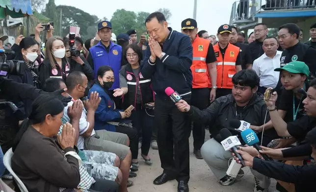 Thailand's Prime Minister Anutin Charnvirakul meets relatives of the victims as he visits the site where a construction crane fell onto a passenger train in Nakhon Ratchasima province, Thailand, Wednesday, Jan. 14, 2026. (AP Photo/Sakchai Lalit)