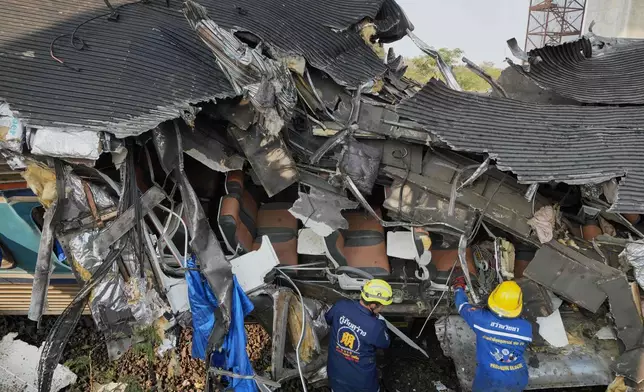 Rescuers work amid the wreckage after a construction crane fell into a passenger train in Nakhon Ratchasima province, Thailand, Wednesday, Jan.14, 2026. (AP Photo/Sakchai Lalit))