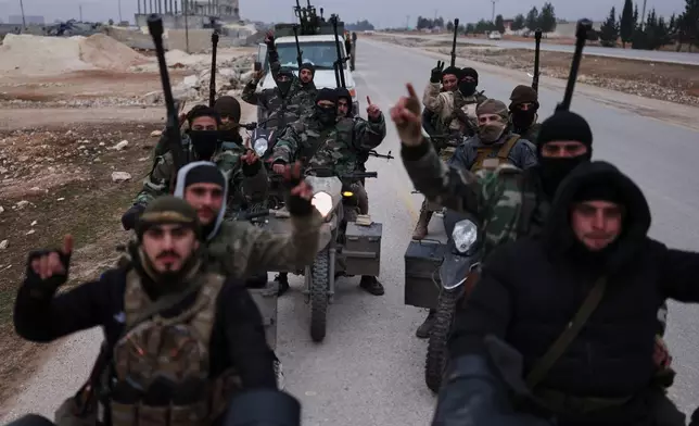 Syrian government soldiers carry machine guns as they ride motorcycles on a road leading to the town of Deir Hafer, Syria, Saturday, Jan. 17, 2026. (AP Photo/Ghaith Alsayed)