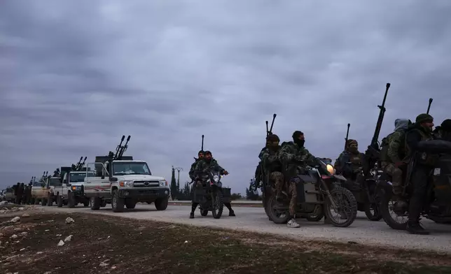 A convoy of Syrian government forces drive on a road leading to the town of Deir Hafer, Syria, Saturday, Jan. 17, 2026. (AP Photo/Ghaith Alsayed)
